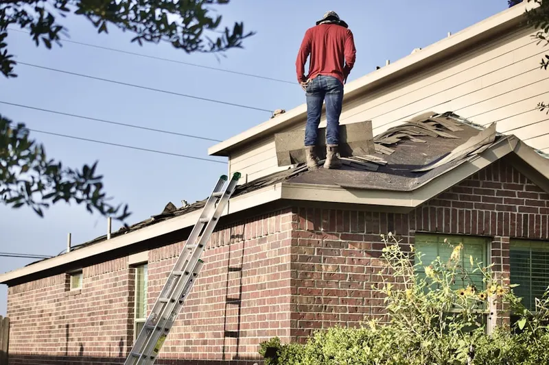 Professional roofer working on a residential roof in Amber